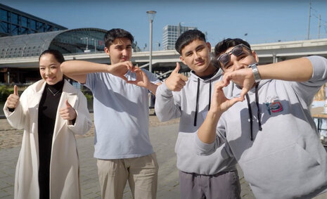Vier junge Menschen halten die Daumen hoch und formen herzen